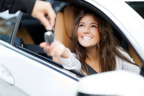 A smiling girl holding car key